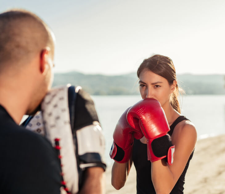 Two people outside boxing and training.